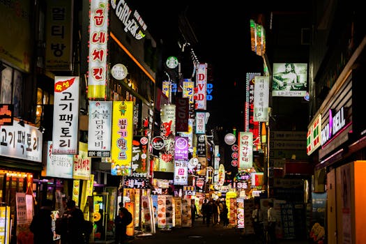 Explore Seoul's vibrant nightlife on a bustling neon-lit street lined with shops and restaurants.